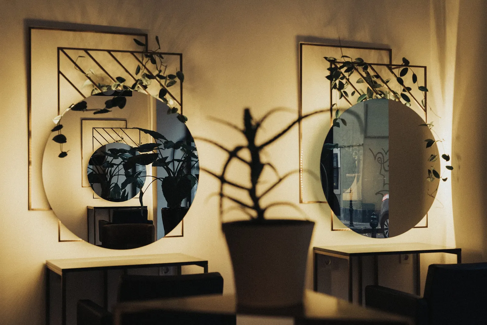 Detajl interierja salona Simon Salon — kovinska stena in okrogla ogledala